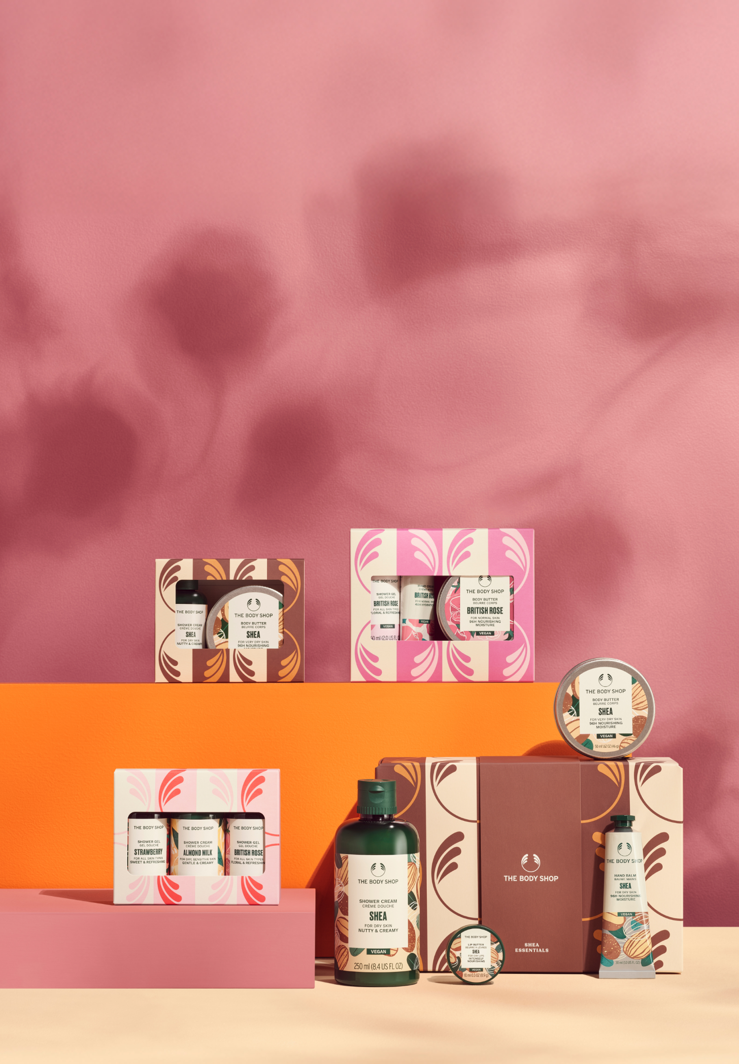 Collection of skincare products and packaging on a pink and orange gradient background