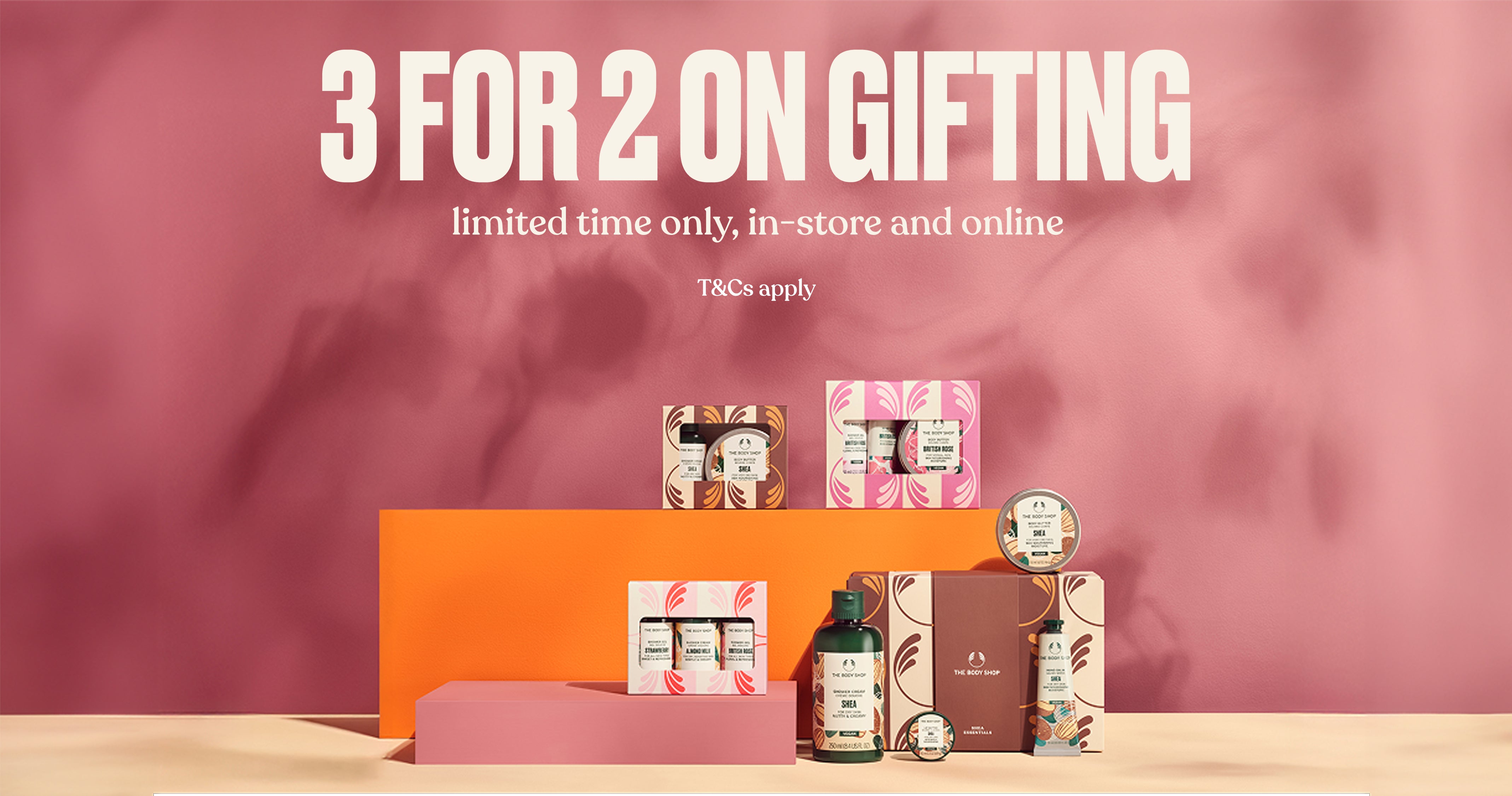 Promotional display with skincare products and '3 for 2 on gifting' text on a pink background